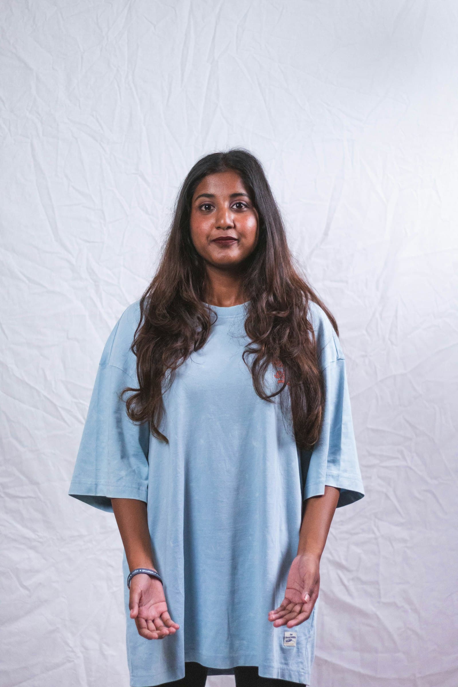 Mulher vestindo camiseta ampla azul-clara lisa (foto ilustrativa)